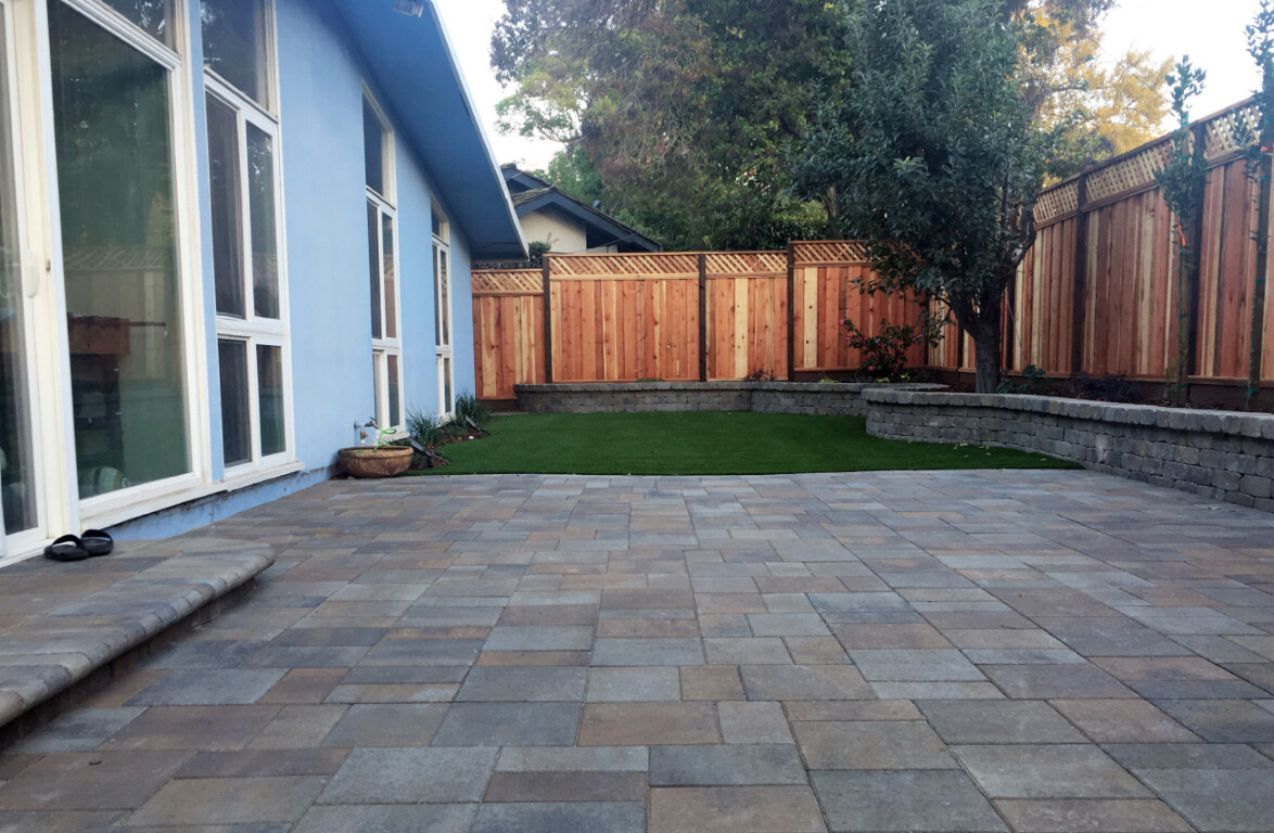 Beautiful paver patio installation with artificial turf showcasing residential concrete work